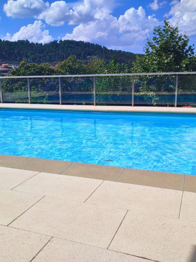 piscina na quinta do lameiro tarouca portugal, com uma vasta floresta verde ao fundo.
