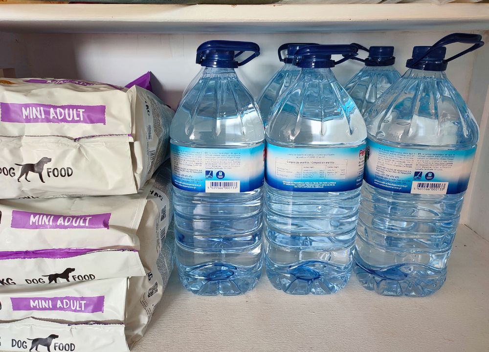 Exemplo de artigos para um kit de sobrevivência em casa - ração para cães e garrafões de agua